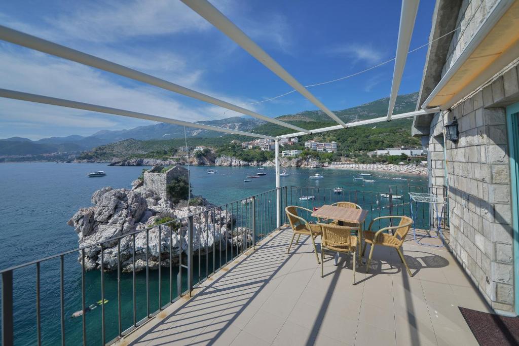 a balcony with a table and chairs and the water at Kazanegra Exclusive Apartments in Sveti Stefan