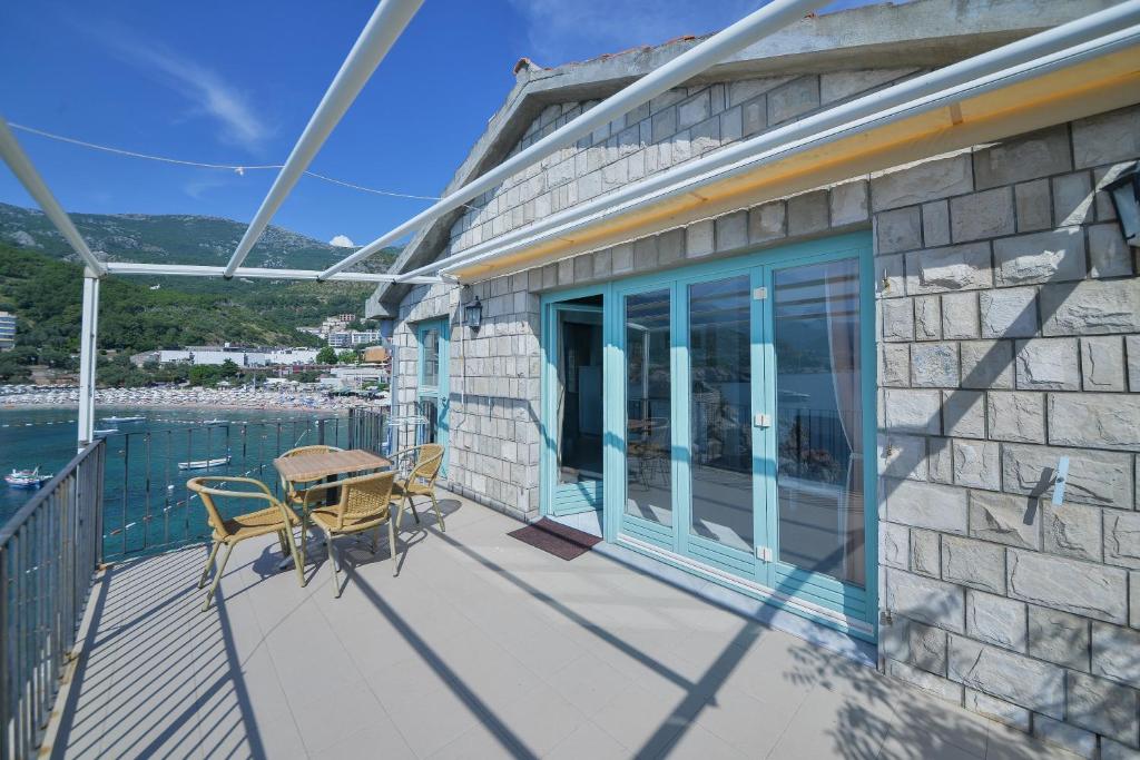 a balcony of a house with a table and chairs at Kazanegra Exclusive Apartments in Sveti Stefan