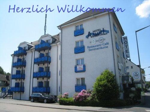 a large white building with blue balconies on a street at Hotel Aggertal in Gummersbach