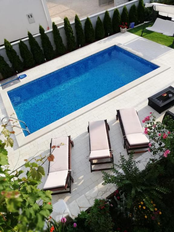 a swimming pool with two lounge chairs and a swimming pool at Apartments Jankovic in Vodice