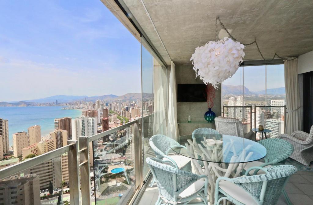 einen Balkon mit einem Tisch und Stühlen sowie Stadtblick in der Unterkunft Mirador del Mediterraneo in Benidorm