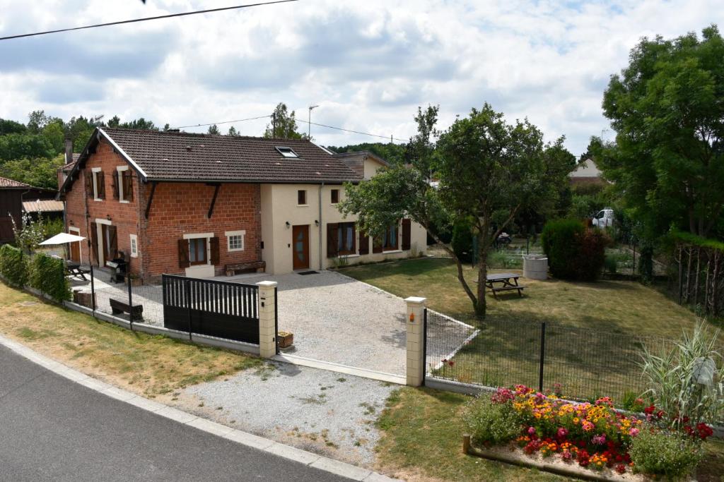 a house with a fence in front of it at Le Deroscope in Arrigny