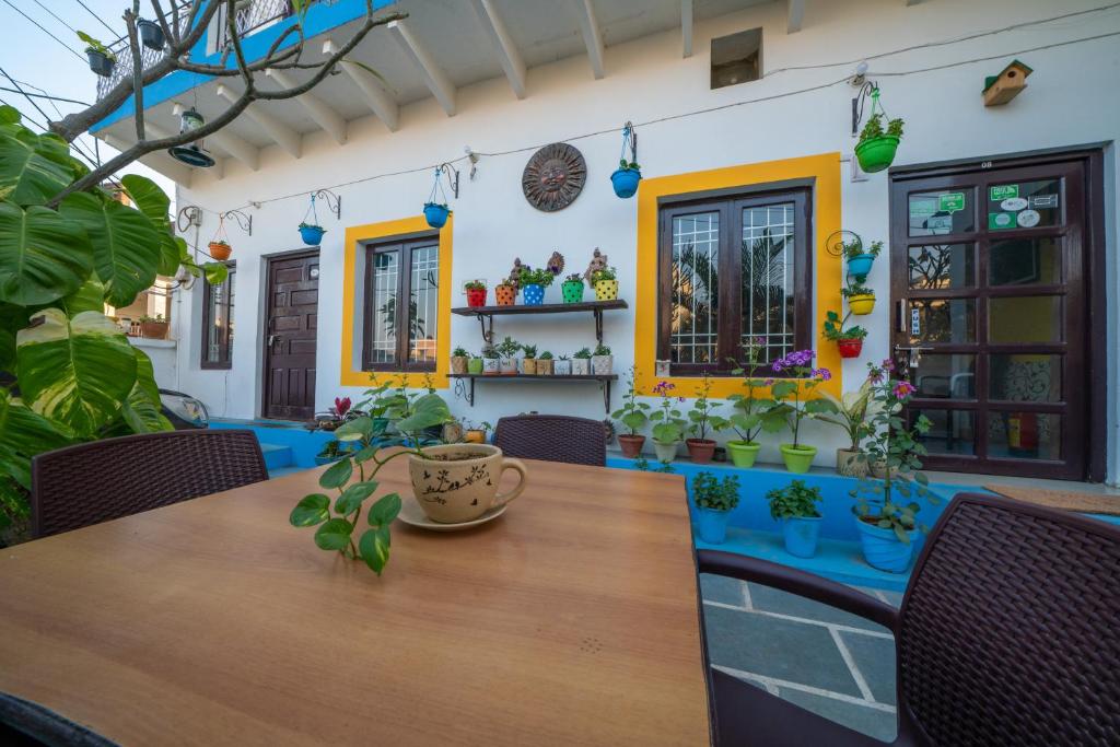 Iora Guest House في بهاراتبور: غرفة طعام مع طاولة مع نباتات الفخار