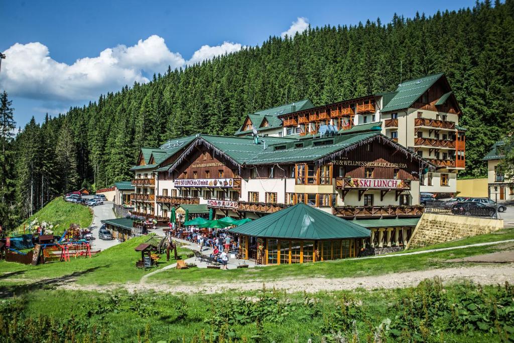 een groot gebouw op een heuvel met mensen ervoor bij Ski & Wellness Residence Družba in Demanovska Dolina