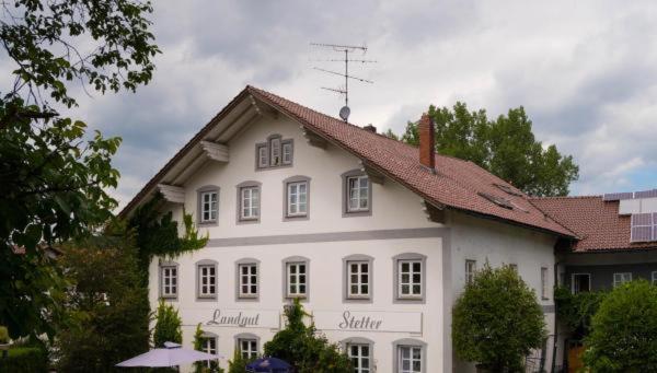 ein großes weißes Haus mit rotem Dach in der Unterkunft Landgut Stetter in Schöllnach