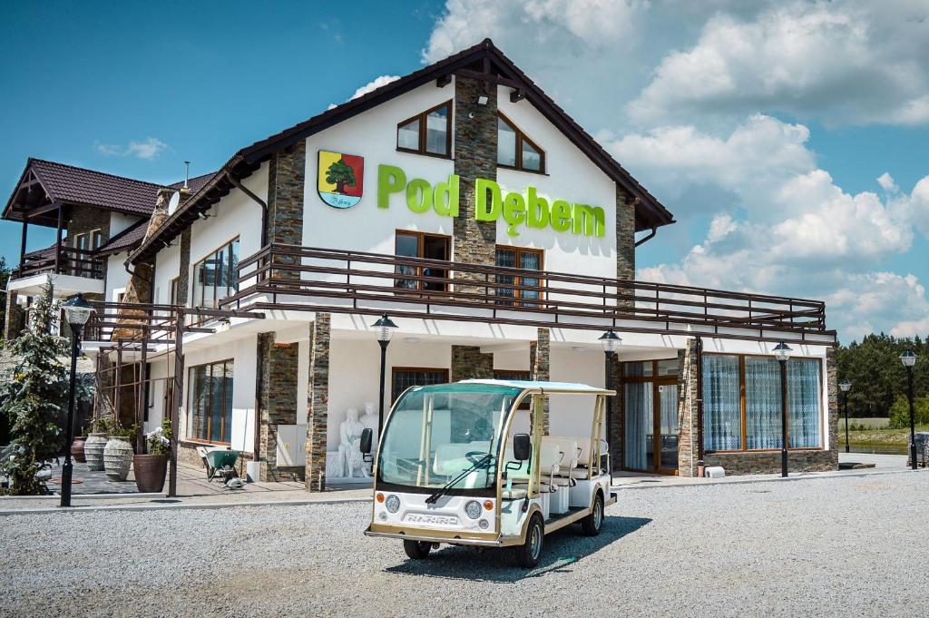 un piccolo veicolo parcheggiato di fronte a un edificio di POD DĘBEM a Osowa