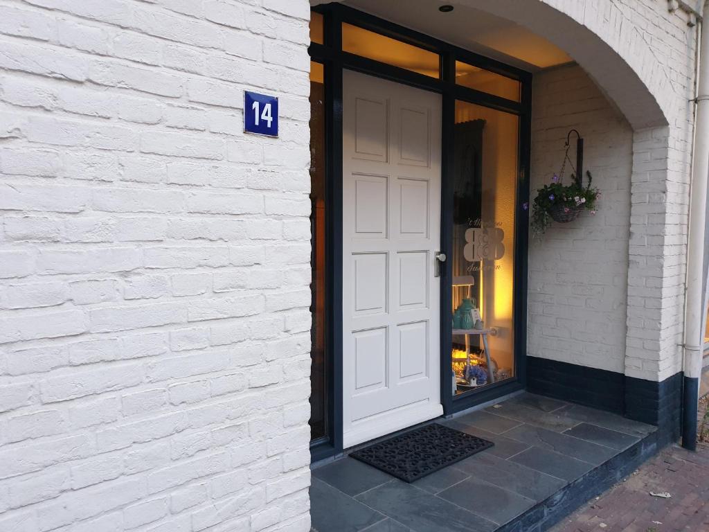 een witte deur aan de zijkant van een gebouw bij B&B 't Merthoes in Susteren