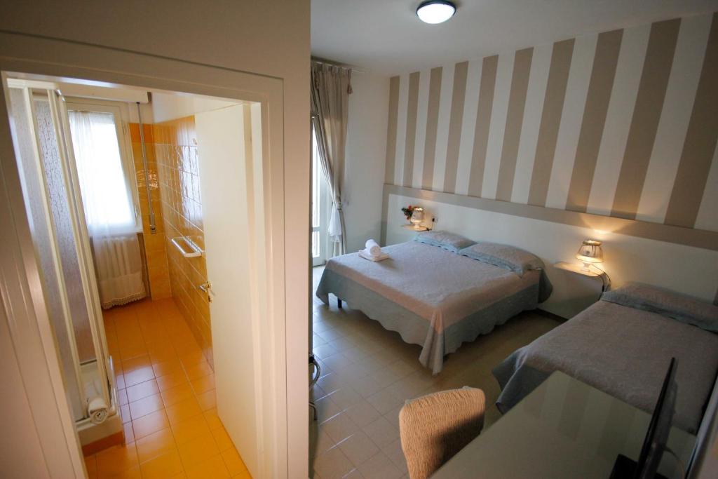 a hotel room with a bed and a hallway at Ponti di Badia in Castiglione della Pescaia