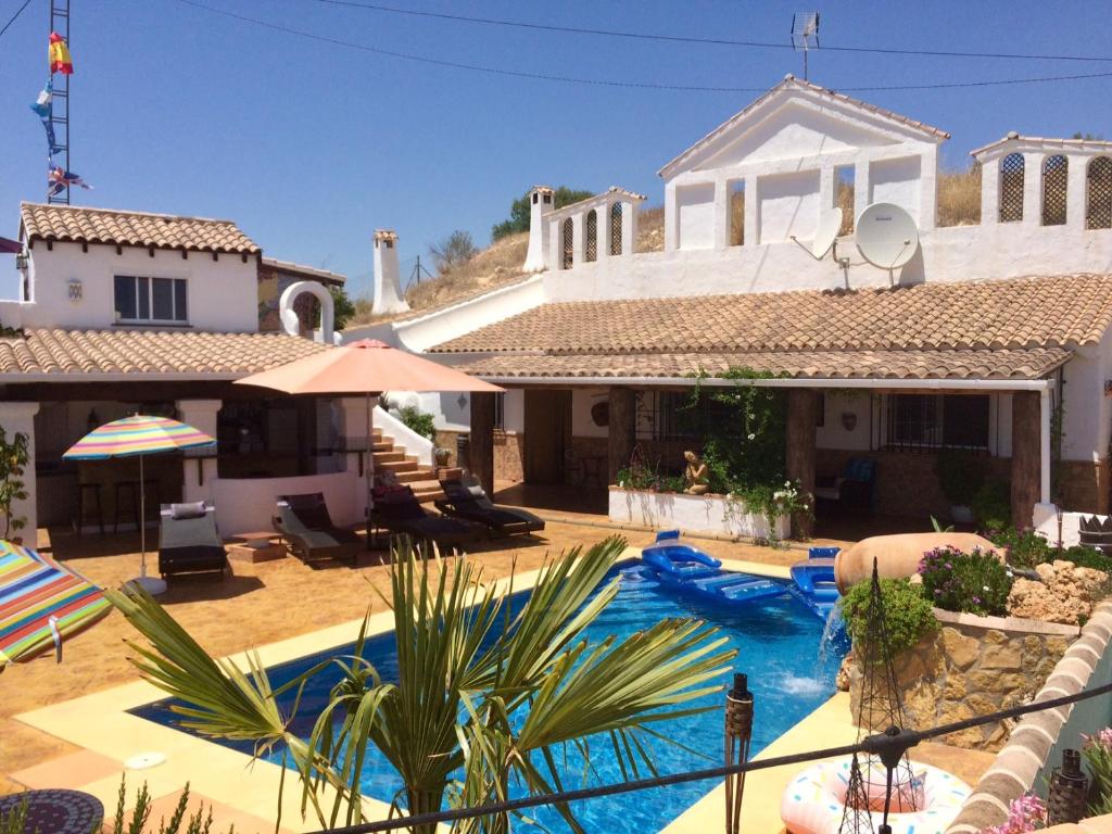 a house with a swimming pool in front of a house at Cueva Romana, Adults Only Cave House in Cuevas del Campo