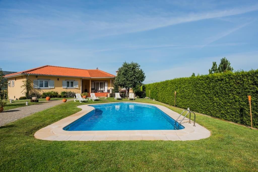 a swimming pool in the yard of a house at Quinta Vila Verde in Cinfães