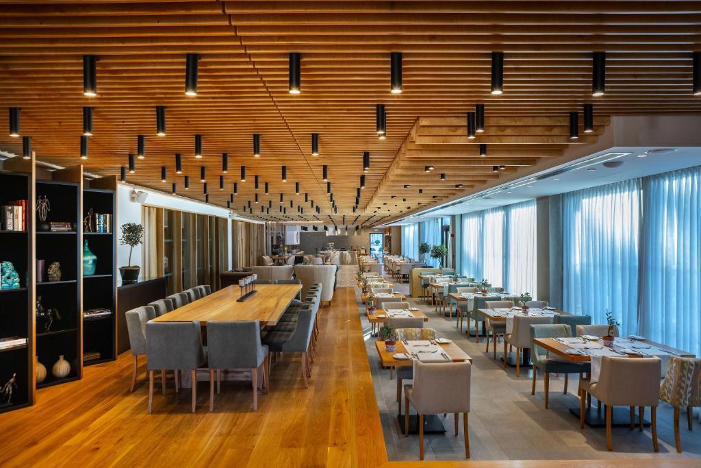 a dining room with long tables and chairs at Anemi Hotel & Suites in Paphos