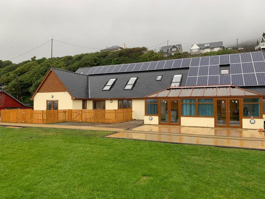 una casa con paneles solares encima en Barmouth Beach Club, en Barmouth