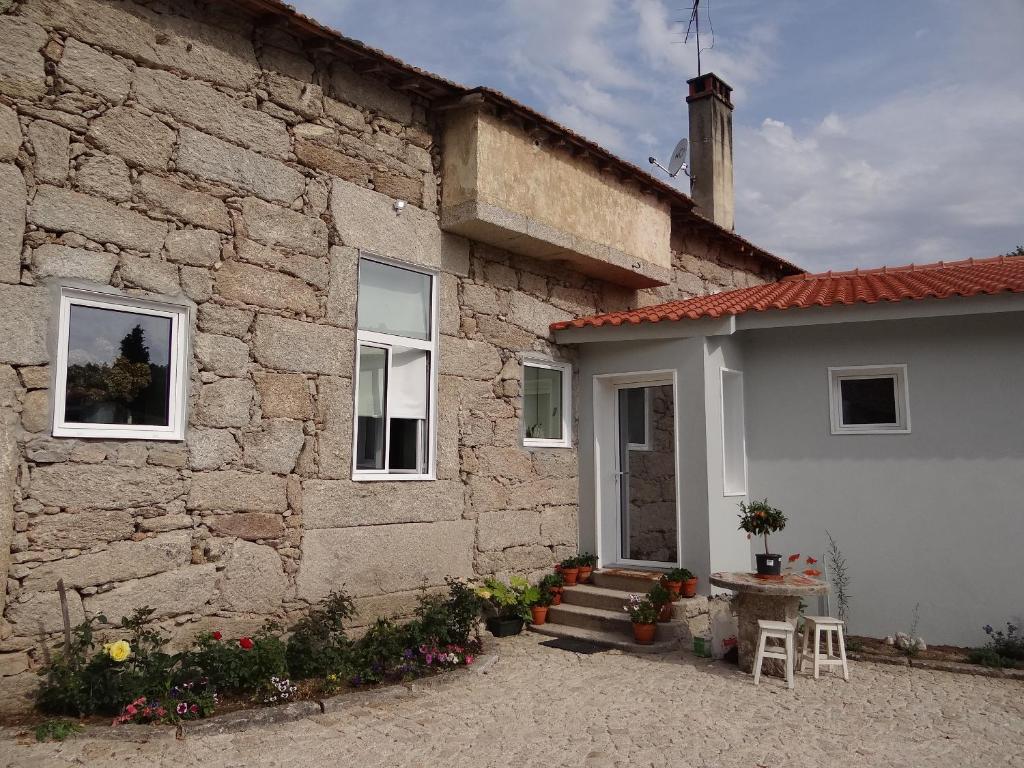 un edificio de piedra con una mesa y sillas junto a él en Museu Casa Aleixo, en Sernancelhe