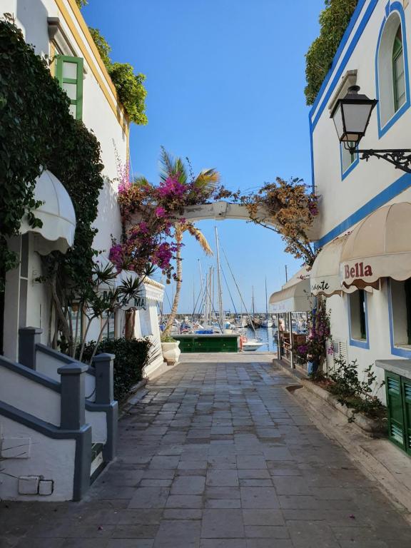 una pasarela entre edificios con un puerto en el fondo en LA GONDOLA, en Puerto de Mogán