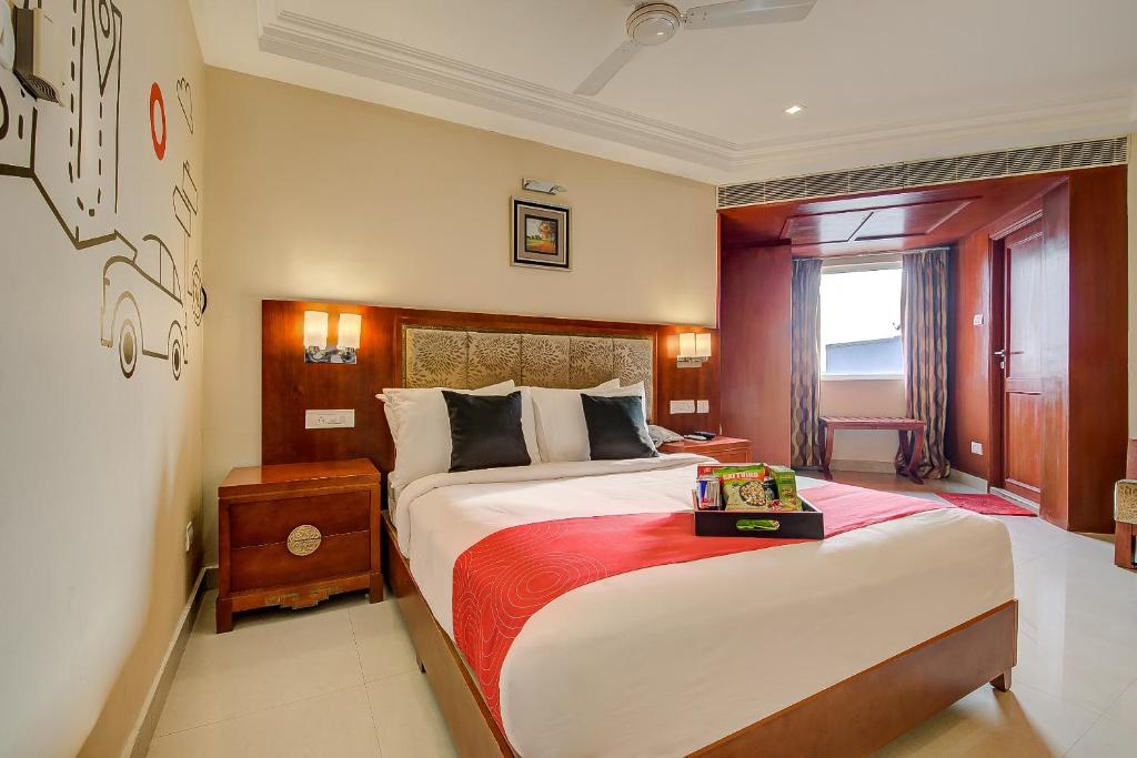 a bedroom with a large bed with a red blanket at Metro Grand Hotel in Chennai