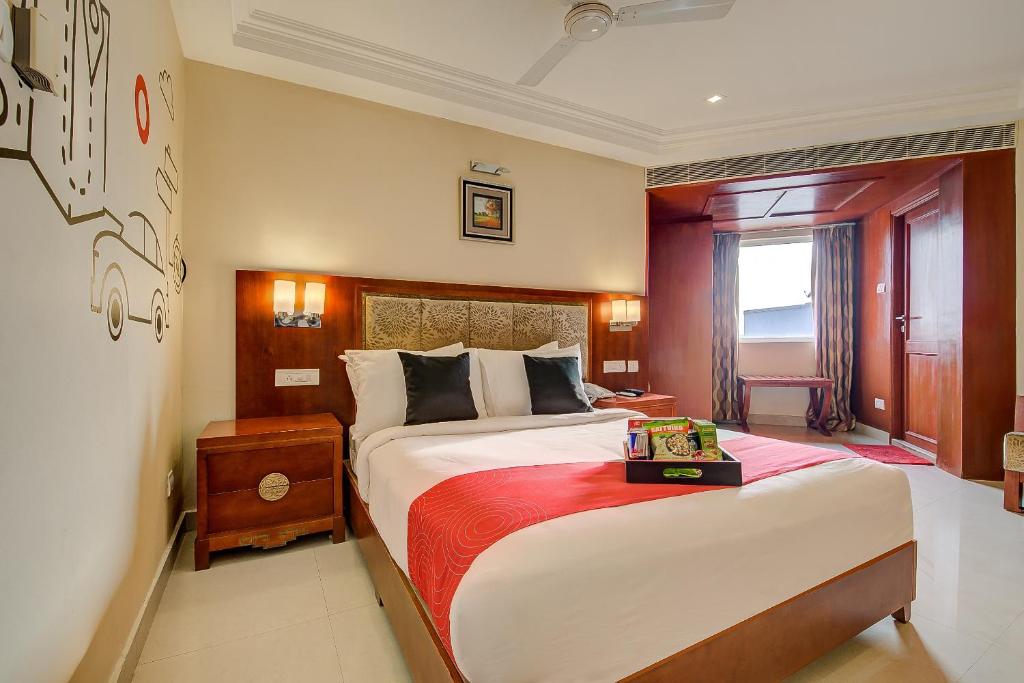 een slaapkamer met een groot bed en een rode deken bij Metro Grand Hotel in Chennai