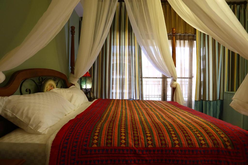 - une chambre avec un grand lit et une couverture rouge dans l'établissement Pulamayama, à Hualien