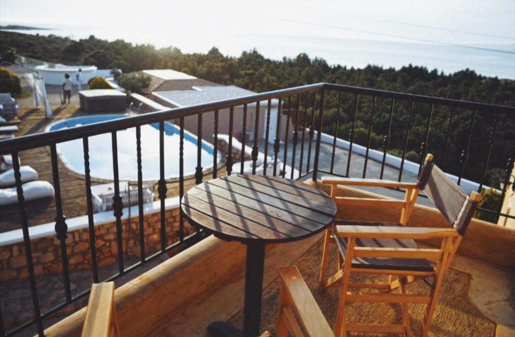 uma mesa e 2 cadeiras numa varanda com piscina em Elafonisos Mare em Elafonisos