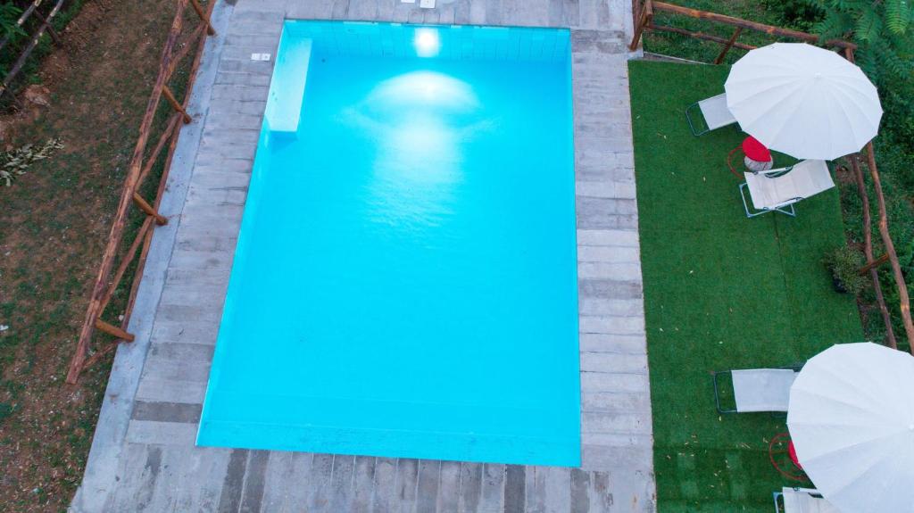 einen Blick über einen blauen Pool mit Sonnenschirmen in der Unterkunft woods house in Pescia