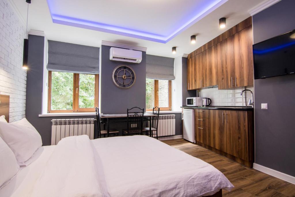 1 Schlafzimmer mit einem großen weißen Bett und einer Küche in der Unterkunft Vip Apartment near Arena City in Kiew