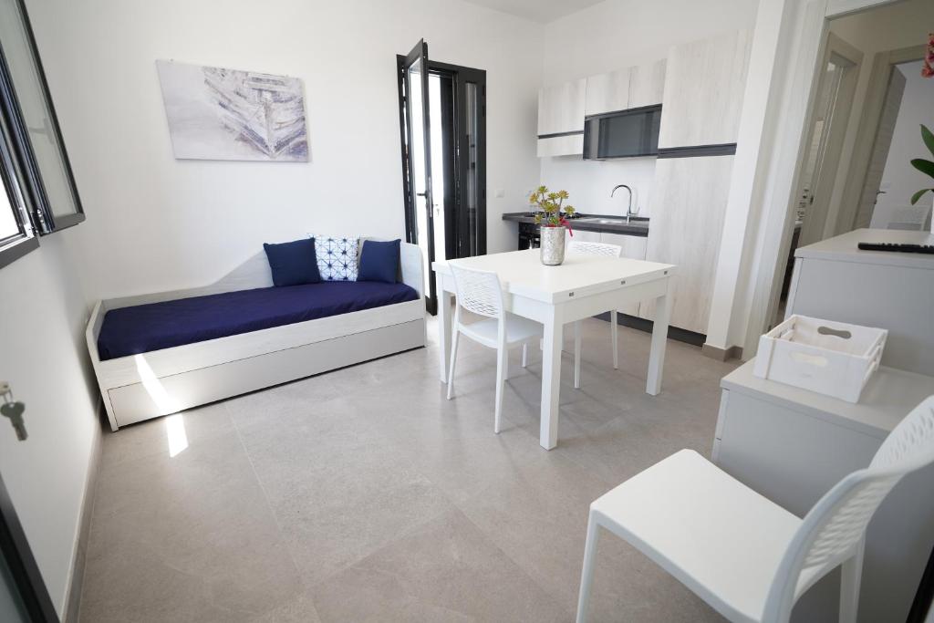 ein kleines Wohnzimmer mit einem Tisch und einem Bett in der Unterkunft Casa vacanza Il Tramaglio in San Foca