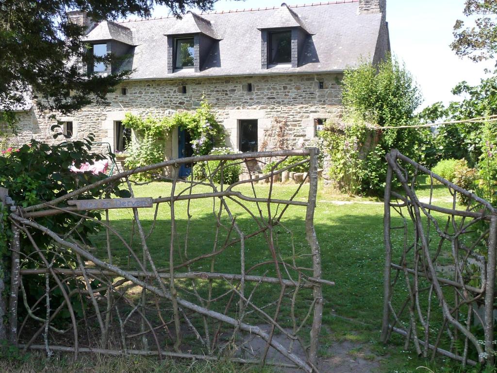 une ancienne maison en pierre avec un portail en face de celle-ci dans l'établissement B&B Chambre d'hôtes et Glamping, Bretagne mer et campagne Brittany sea and countryside, à Pleumeur-Gautier