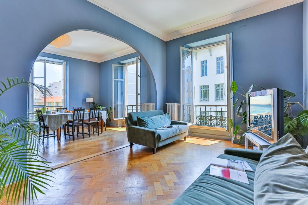 - un salon avec des murs bleus, une table et des chaises dans l'établissement Maison Bianchi - 24 Paul Deroulede, à Nice