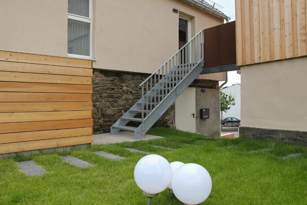 two white balloons in the grass in front of a house at Ferienhaus am Rheinsteig / Nähe Hindenburghöhe / Loreley in Lykershausen