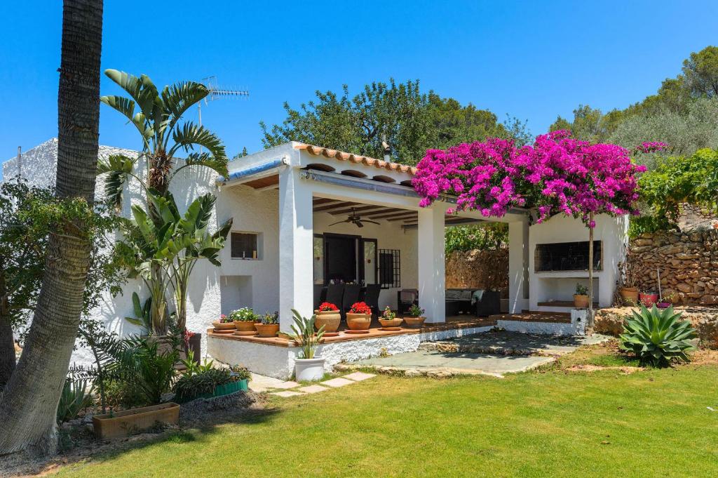 a house with pink flowers in a yard at Villa Benirrás in Sant Miquel de Balansat