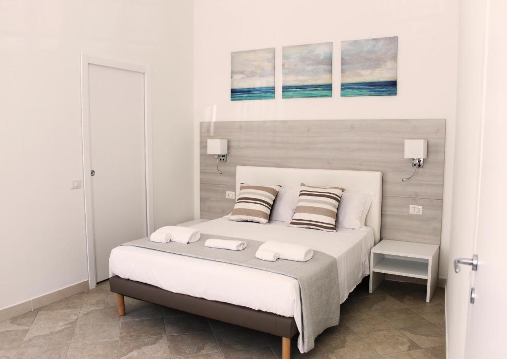 um quarto branco com uma cama grande e 2 almofadas em Suite 14 em Castellammare di Stabia