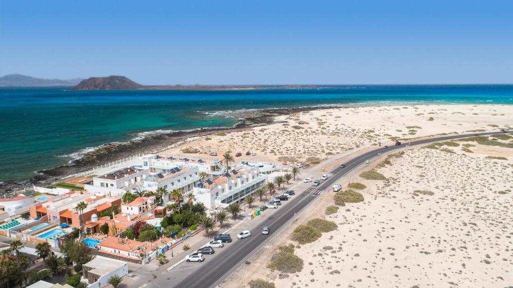 an aerial view of a beach with cars parked at Hotel Boutique TAO Caleta Mar in Corralejo