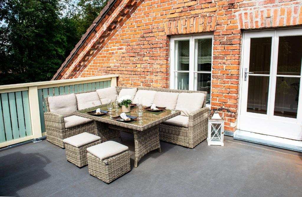a patio with wicker chairs and a table on a balcony at Lossi 32 Penthouse in Tartu