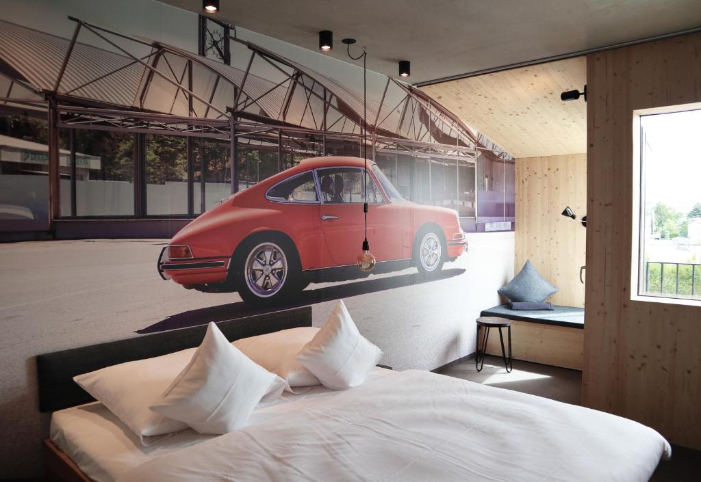 a bedroom with a bed with a car on the wall at elferrooms Hotel in Ubstadt-Weiher