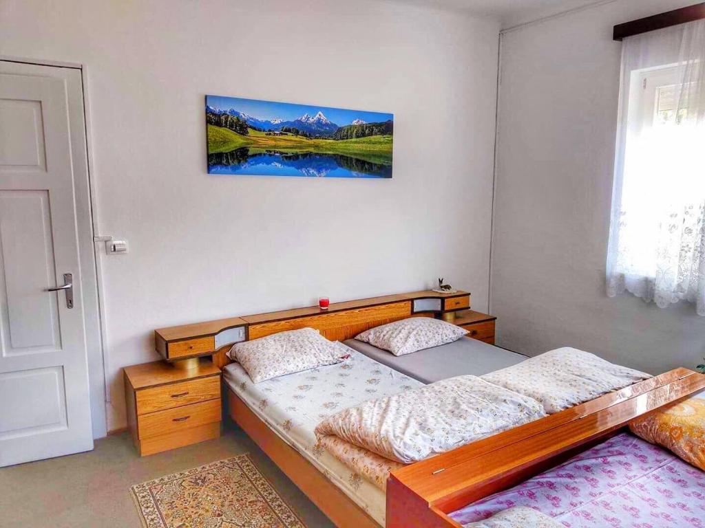 um quarto com uma cama de madeira e uma janela em Apartma Vita em Rečica ob Savinji