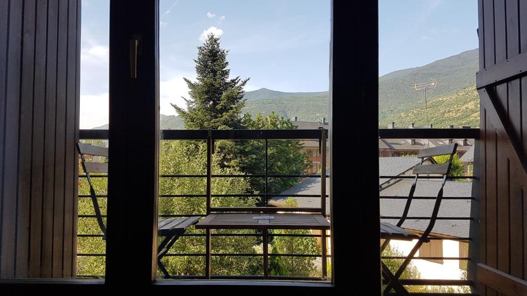una ventana abierta con vistas a un árbol en Family Duplex Esterri, en Esterri d'Àneu
