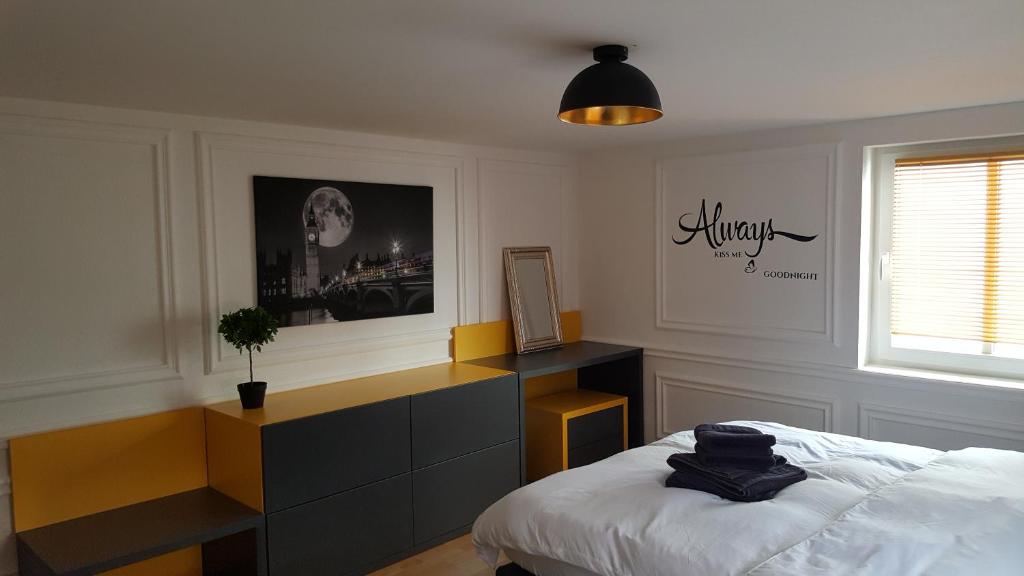 a bedroom with a bed and a desk and a window at London Apartments in Rheineck