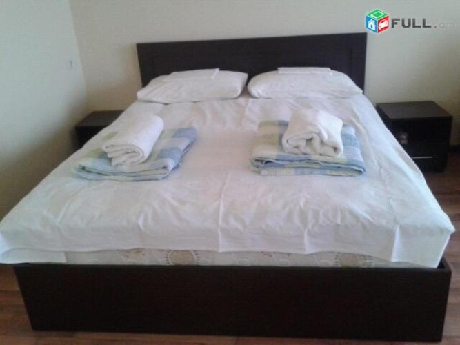 ein weißes Bett mit Handtüchern und Kissen darauf in der Unterkunft НАПРОТИВ СПОРТИВНО-КОНЦЕРТНОГО КОМПЛЕКСА in Yerevan