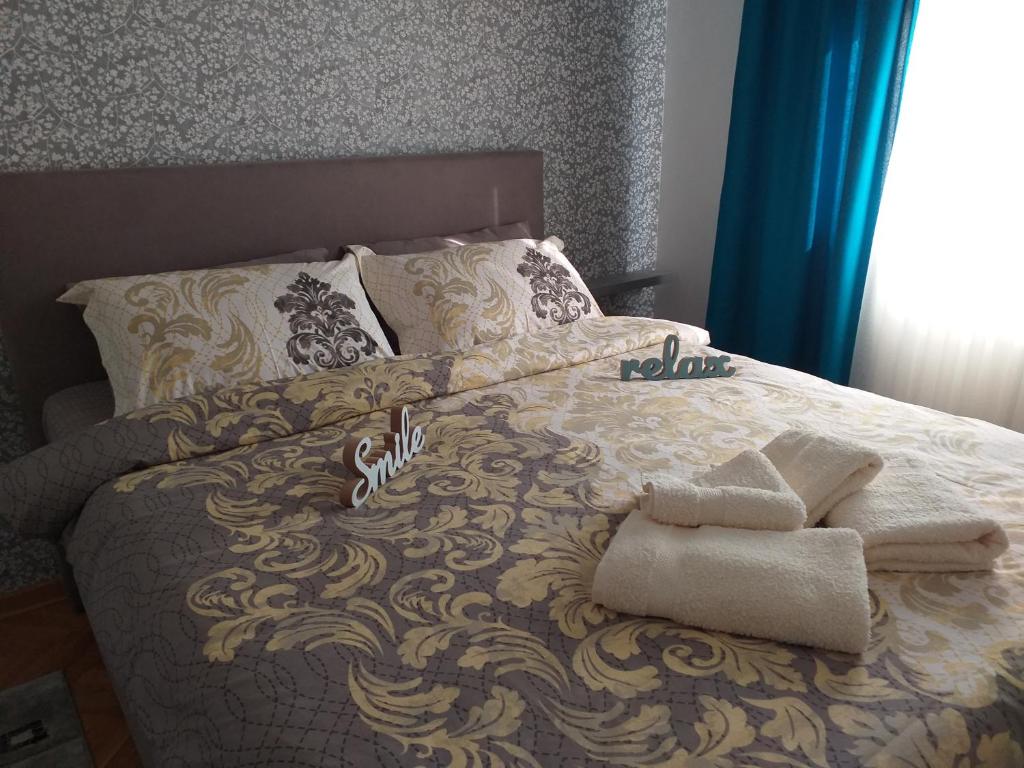 - un lit avec des serviettes et des oreillers dans l'établissement Apartman MINIKI, à Vrnjačka Banja