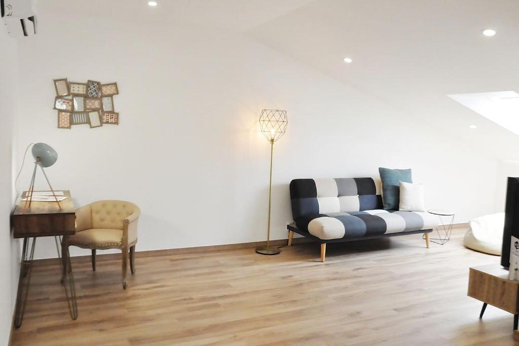 a living room with a couch and a chair at Loft acolhedor em Fátima perto do Santuário in Fátima