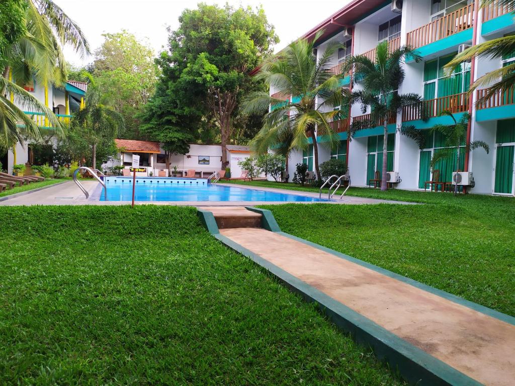 a swimming pool in front of a building at ACME Grand Hotel in Habarana