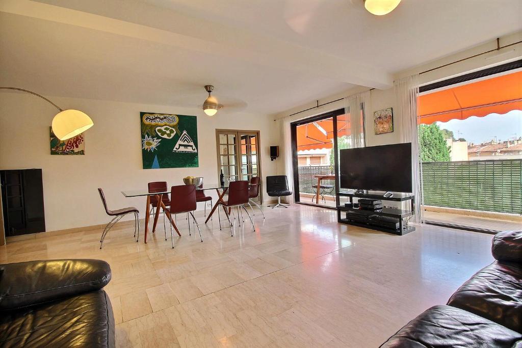 un salon avec une télévision, une table et des chaises dans l'établissement Leï Tapenié par Dodo-a-Cassis, à Cassis