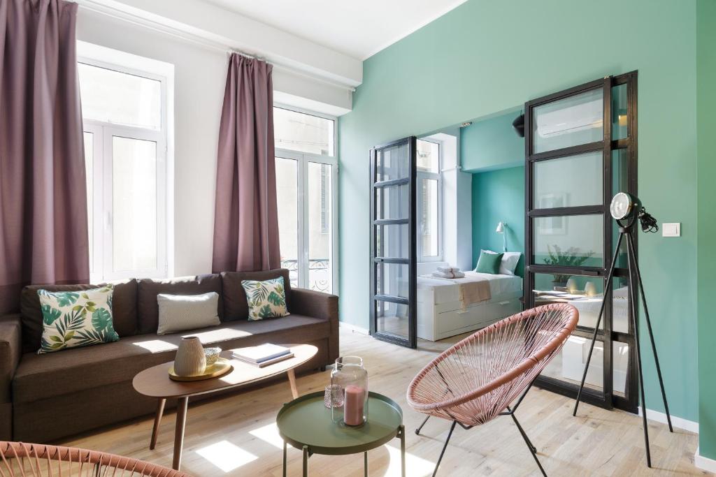 a living room with a couch and a table and chairs at Boutique Central Apartments Acropolis View in Athens
