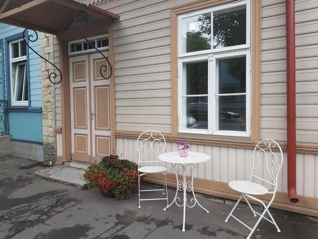 un tavolo e due sedie seduti fuori da una casa di Posti 22 külaliskorter a Haapsalu
