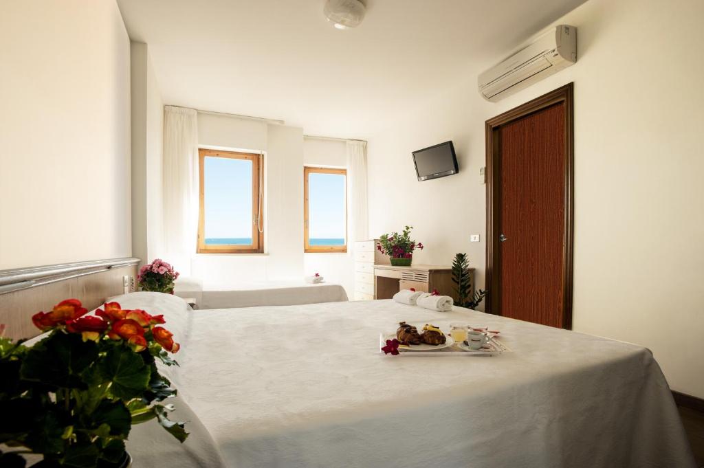 a bedroom with a bed with a plate of food on it at Hotel Esperia in Alba Adriatica