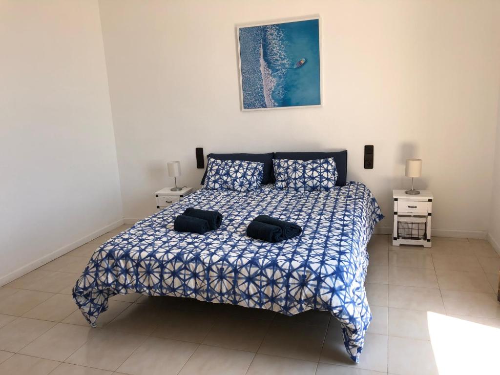 a bedroom with a bed with a blue and white comforter at Apartamento Puerto de Sagunto Playa in Puerto de Sagunto