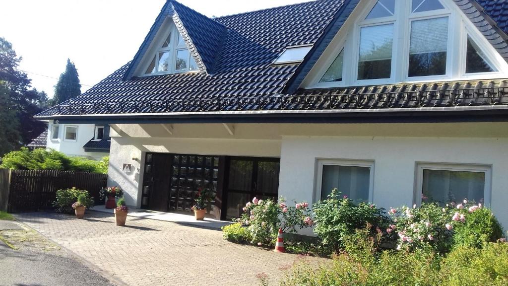 una casa con techo negro y algunas plantas en Haus Papst Johannes Paul. II. en Nümbrecht