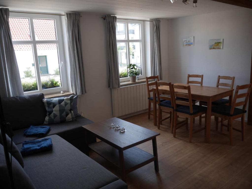 a living room with a table and chairs and a couch at Alte Schmiede Sagard in Sagard