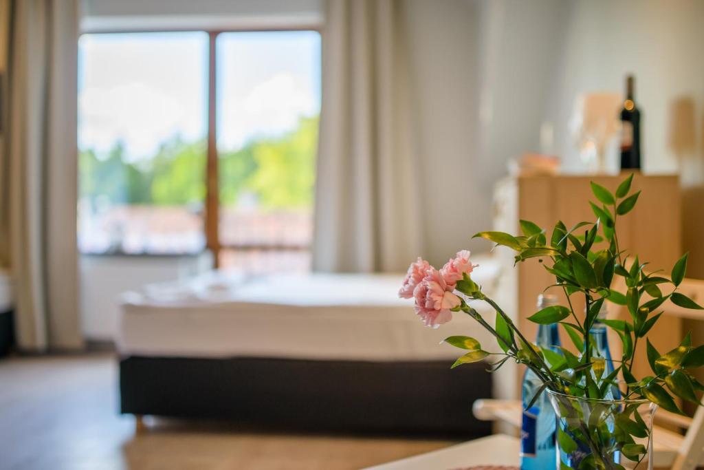 a bedroom with a bed and a vase with a flower at Przystań Przy Lesie in Jantar