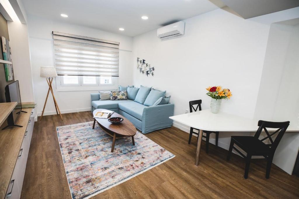 - un salon avec un canapé bleu et une table dans l'établissement Gaspar Apartment - 4th floor - Renovated 2019, à Athènes