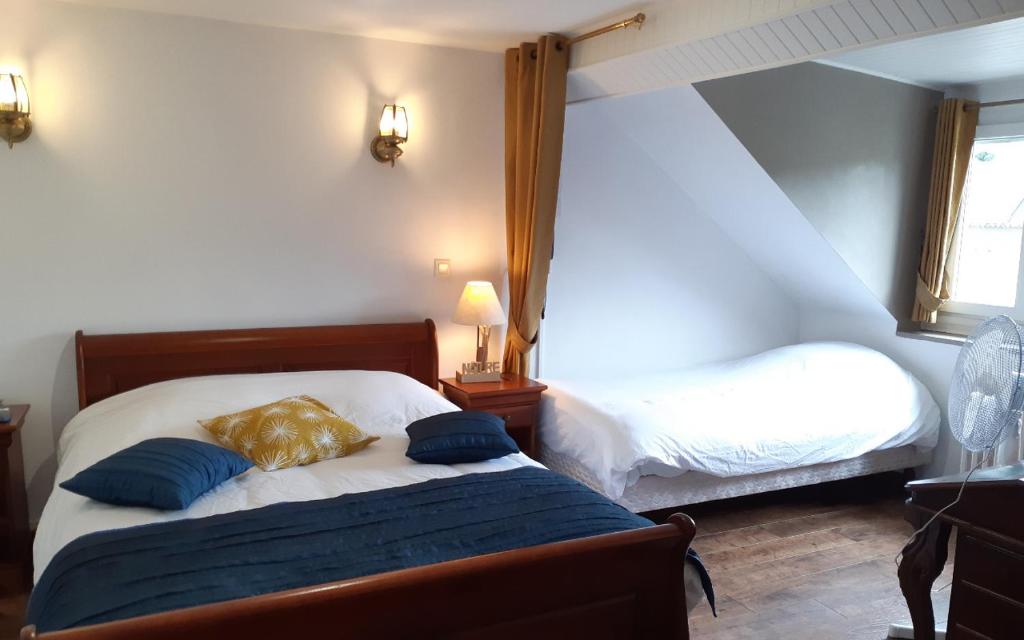 a bedroom with two beds with blue pillows at Logis Le Saint Hubert in Haybes